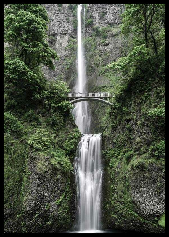 High waterfall with stone bridge, surrounded by greenery, photographic-12