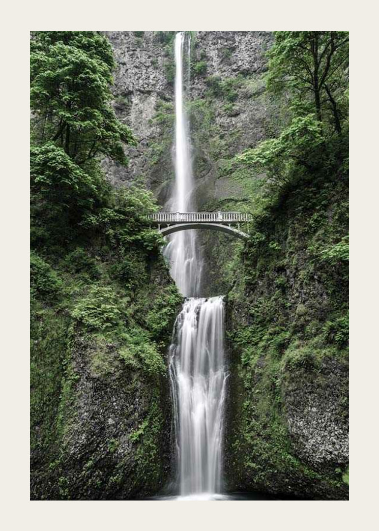 High waterfall with stone bridge, surrounded by greenery, photographic-12