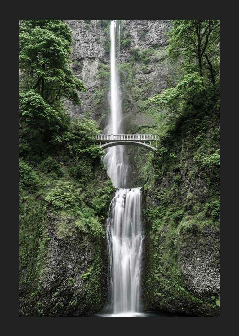 Høy foss med steinbro, omgitt av grøntområder, fotografisk-12