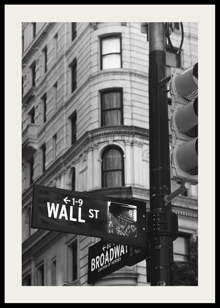 Black and white photographed road sign with text Wall Street-12
