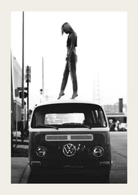 Foto em preto e branco de uma jovem no teto de um ônibus VW em ambiente urbano-3