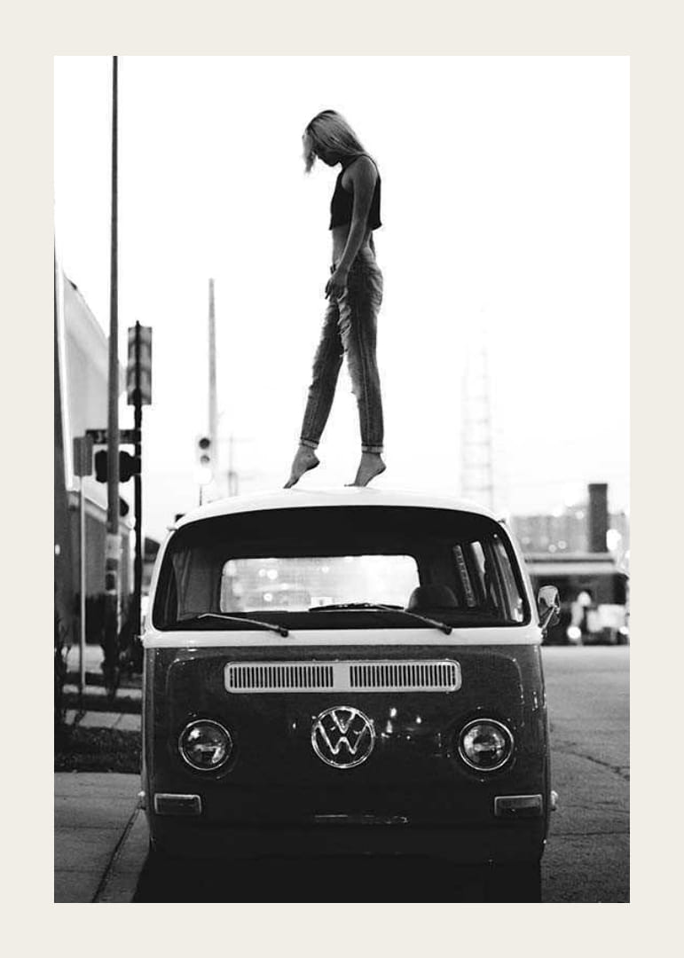 Foto em preto e branco de uma jovem no teto de um ônibus VW em ambiente urbano-12