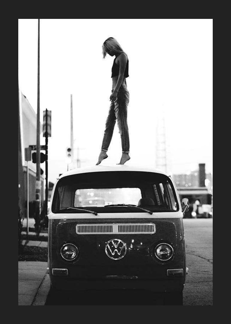 Foto em preto e branco de uma jovem no teto de um ônibus VW em ambiente urbano-12