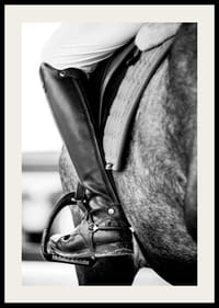 Svart-hvitt-nærbilde av ridestøvler i stigbøyler på hesteryggen-2