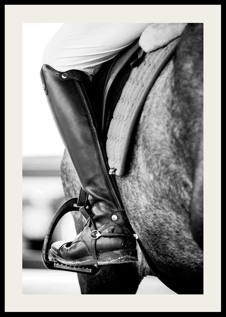Svart-hvitt-nærbilde av ridestøvler i stigbøyler på hesteryggen-12