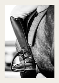 Svart-hvitt-nærbilde av ridestøvler i stigbøyler på hesteryggen-3