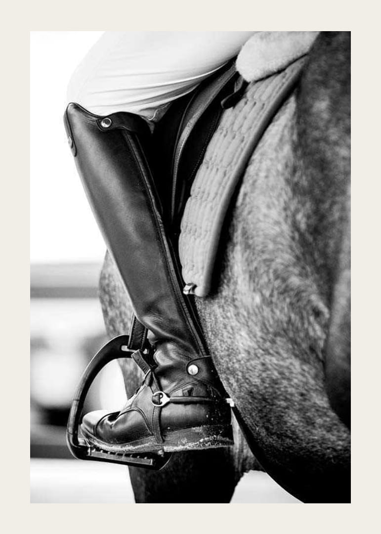 Svart-hvitt-nærbilde av ridestøvler i stigbøyler på hesteryggen-12