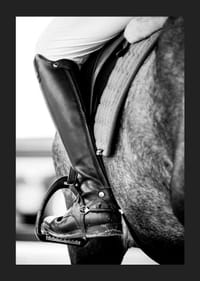 Svart-hvitt-nærbilde av ridestøvler i stigbøyler på hesteryggen-5