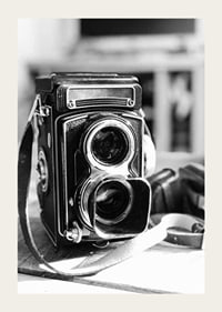 Black and white close-up of vintage two-lens analog camera on table-3