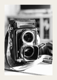 Black and white close-up of vintage two-eyed analog camera on table-3