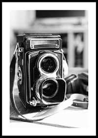 Black and white close-up of vintage two-lens analog camera on table-0