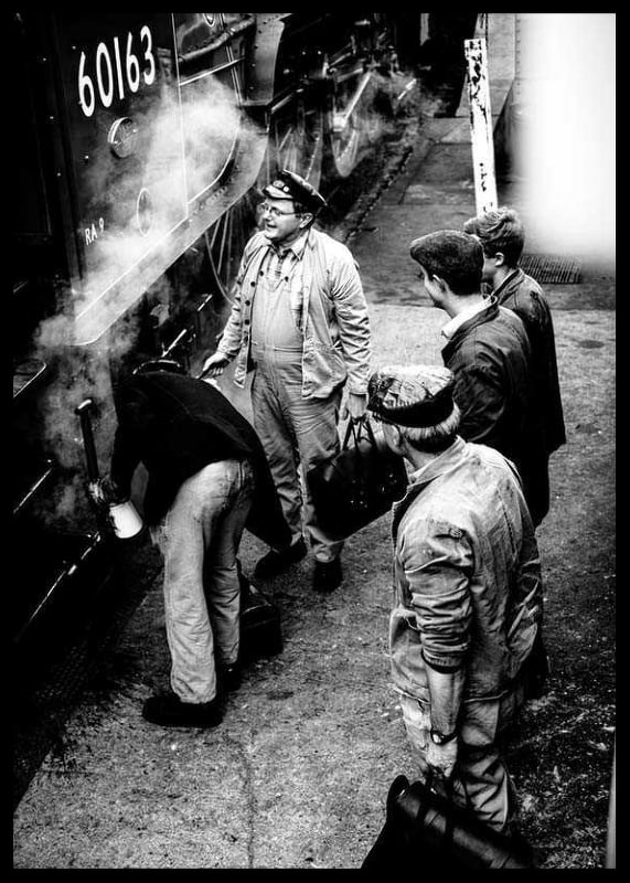 Black and white photo of men by steam locomotive on railway platform-12