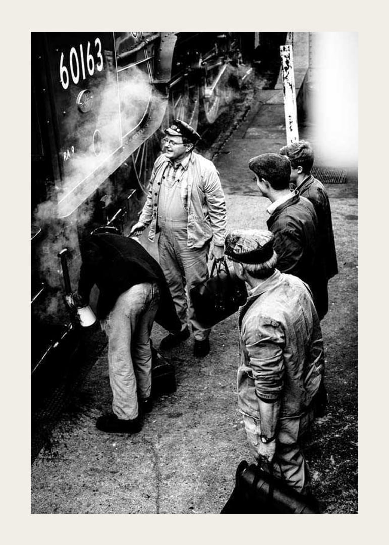 Black and white photo of men by steam locomotive on railway platform-12