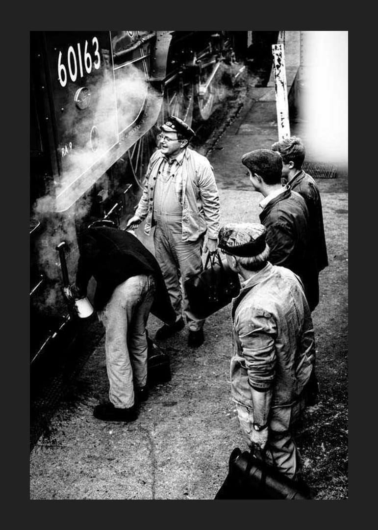 Czarno-białe zdjęcie mężczyzn przy lokomotywie parowej na peronie kolejowym-12