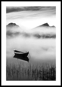 Black and white rowboat on foggy lake with mountains in the background-0