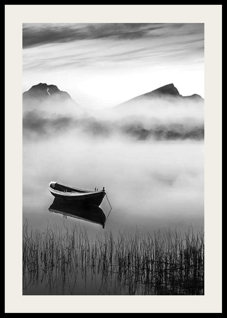 Black and white rowboat on foggy lake with mountains in the background-12