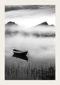 Barque noire et blanche sur un lac brumeux avec des montagnes en arrière-plan-3