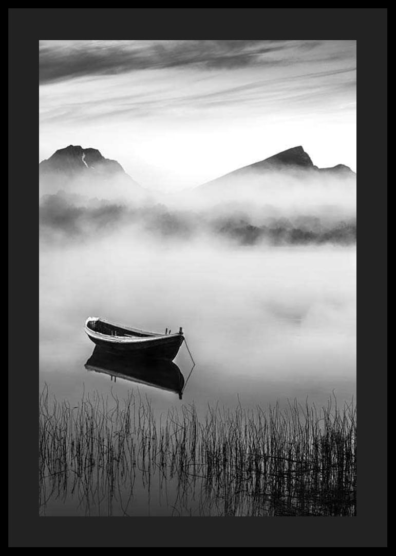 Black and white rowboat on foggy lake with mountains in the background-12