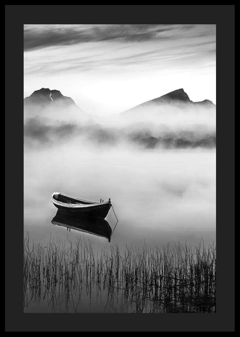 Barque noire et blanche sur un lac brumeux avec des montagnes en arrière-plan-12