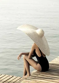 Photograph of woman in black swimsuit with large bright hat-7