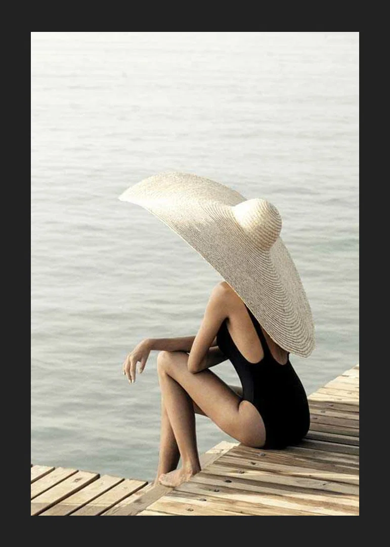 Photograph of woman in black swimsuit with large bright hat-12