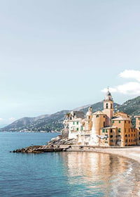 Fotografi av italienska kusthus vid havet med berg bakom-7
