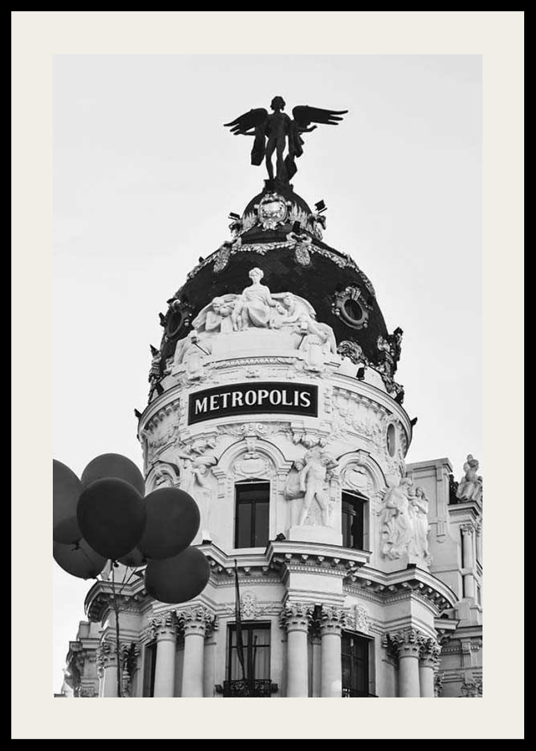 Black and white photo of the Metropolis building in Madrid with balloons-12