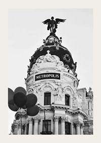 Black and white photo of the Metropolis building in Madrid with balloons-3