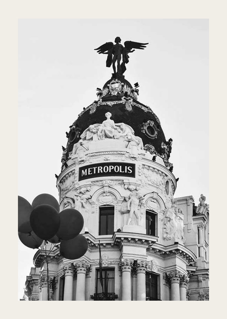 Black and white photo of the Metropolis building in Madrid with balloons-12