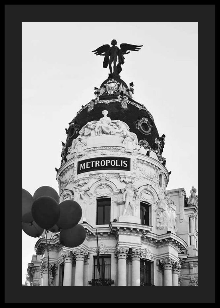 Black and white photo of the Metropolis building in Madrid with balloons-12
