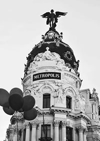 Black and white photo of the Metropolis building in Madrid with balloons-7