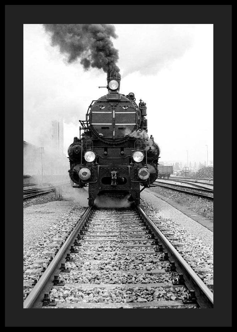 Black and white photograph of steam locomotive running straight towards the camera-12
