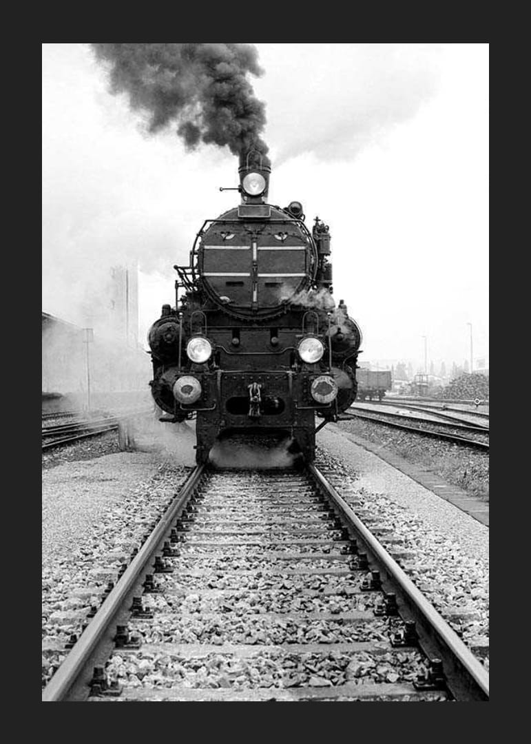 Svartvit fotografi av ånglok som kör rakt mot kameran-12