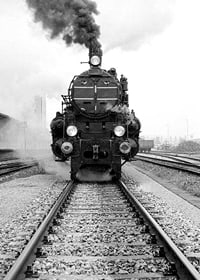 Black and white photograph of steam locomotive running straight towards the camera-7