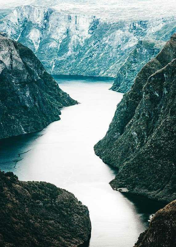 Fotografiskt fjordlandskap med branta berg och blå toner-12