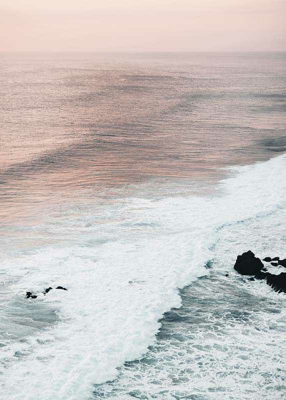 Photograph of ocean waves against coastal rocks in soft pink tones-12