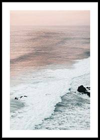 Photograph of ocean waves against coastal rocks in soft pink tones-0