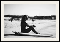 Black and white photo of woman on surfboard at sandy beach-2