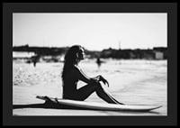 Black and white photo of woman on surfboard at sandy beach-4