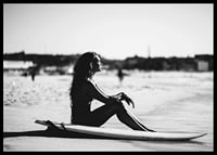 Black and white photo of woman on surfboard at sandy beach-6