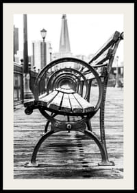 Čiernobiela fotografia lavičky v parku na drevenom móle s panorámou mesta-2