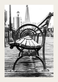 Čiernobiela fotografia lavičky v parku na drevenom móle s panorámou mesta-3