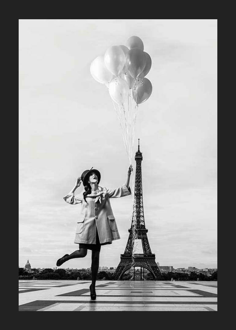 Black and white photo of woman with balloons at the Eiffel Tower-12