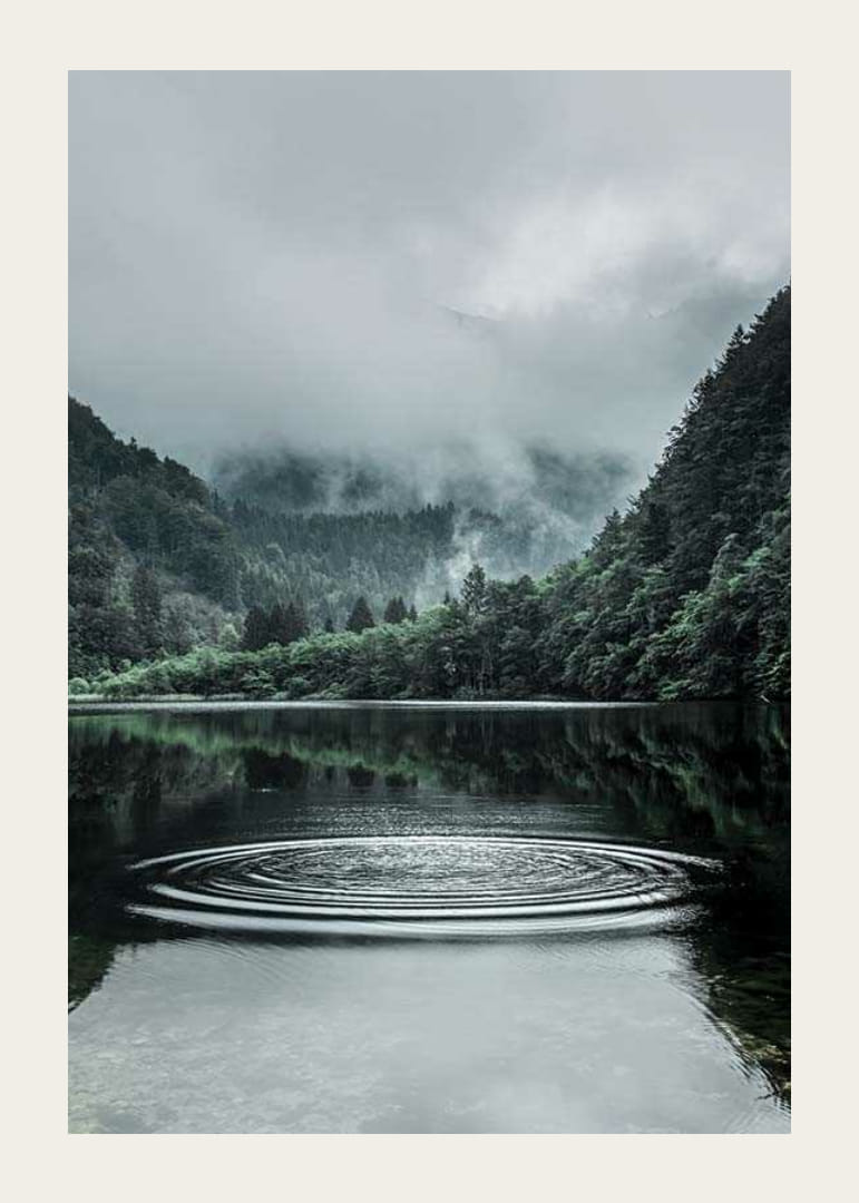 Fotografiskt landskap med dimhöljda berg och lugn sjö-12