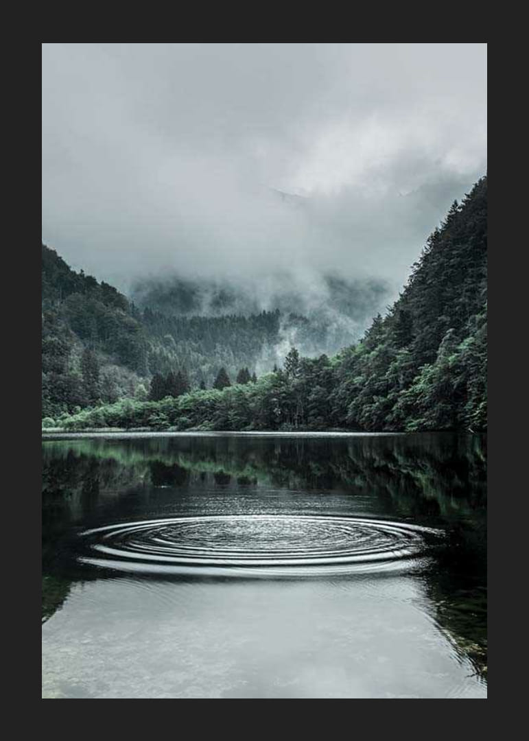 Fotografiskt landskap med dimhöljda berg och lugn sjö-12
