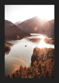Fotografia di un lago illuminato dal sole e circondato da montagne boscose-5