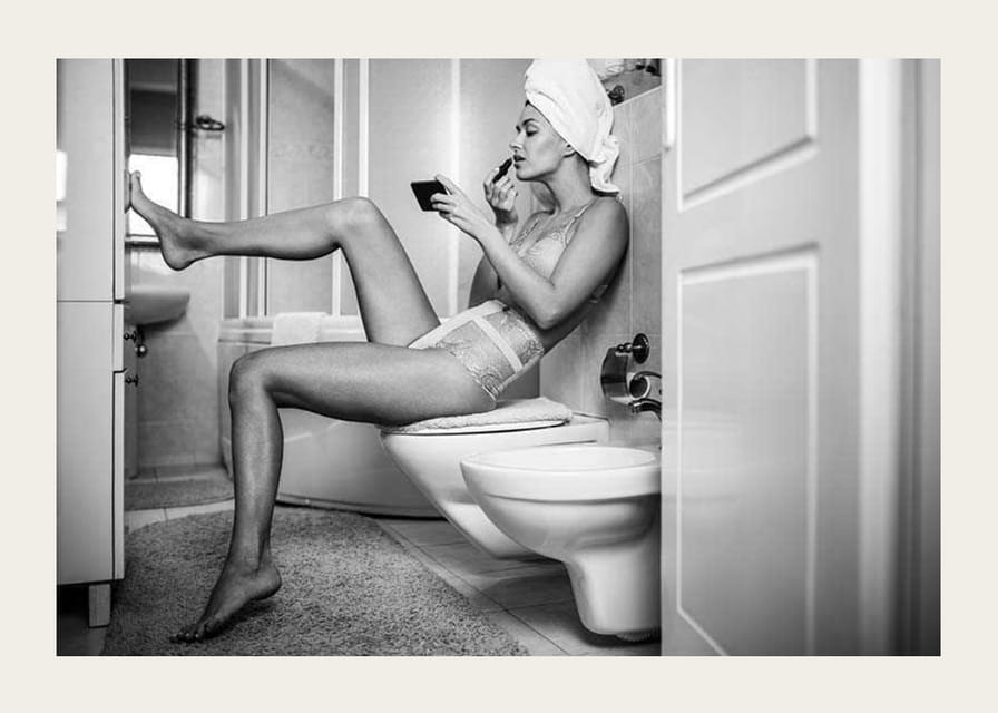 Czarno-białe zdjęcie kobiety w bieliźnie nakładającej makijaż w łazience-12