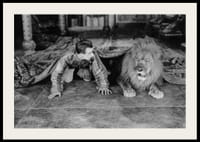 Čiernobiela fotografia mladého muža a leva na podlahe v interiéri-2