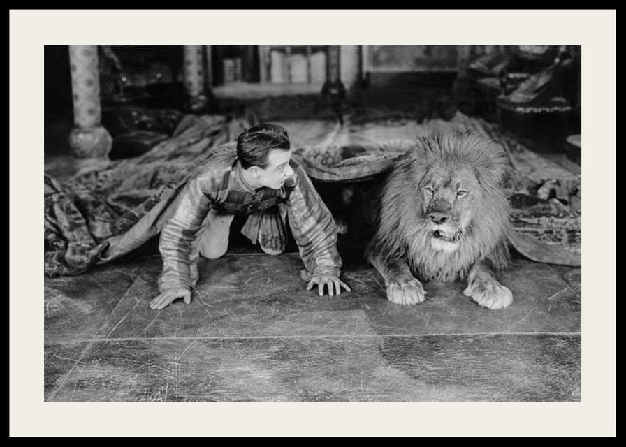 Čiernobiela fotografia mladého muža a leva na podlahe v interiéri-12