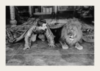 Čiernobiela fotografia mladého muža a leva na podlahe v interiéri-3